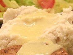 meatloaf with gravy and mashed potatoes on a plate next to salad