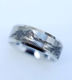 a wedding band with mountains engraved on it