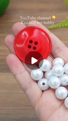 a person holding a red button with white pearls in their palm and the words you're channeling my hobby