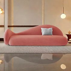 a pink couch sitting on top of a shiny floor next to a table and lamp