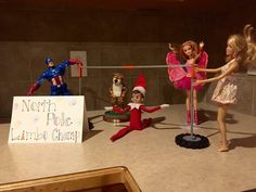 three dolls are posed in front of a sign that says north pole limbo point