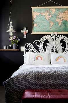 a bedroom with a map hanging above the headboard and pillows on the bed in front of it