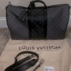 Brand New Authentic Louis Vuitton Keepall 50 Bandouliere Monogram Eclipse Coated Canvas And Monogram Eclipse Reverse Coated Canvas M45392 Was Purchased When It First Released And Never Used. Just Sat On Display In Closet. The Keepall Bandoulire 50 Alternates Blocks Of Dark Monogram Eclipse Canvas With Lighter Monogram Eclipse Reverse To Create A Bold Masculine Feel. This Classic Soft Travel Bag Boasts Leather Top Handles And Two Leather Bands Along The Side, All In Black, Making It Instantly Rec Luxury Gray Business Bags, Designer Gray Travel Bag, Luxury Black Monogram Canvas Bags, Designer Bags With Gunmetal Hardware, Luxury Black Bag With Gunmetal Hardware, Black Monogram Canvas Bag For Everyday Luxury, Black Monogram Canvas Luxury Bag, Louis Vuitton Keepall 55, Louis Vuitton Speedy 40