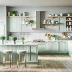 a kitchen filled with lots of green cabinets and counter top space next to two stools