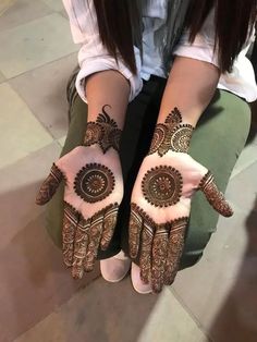 a woman's hands with hennap on her hand and the bottom half of her arm