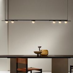 a dining table with four lights hanging from it