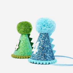 two small hats with blue and green pom poms