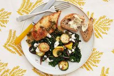 a white plate topped with bread and veggies on top of a yellow table cloth