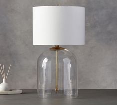 a lamp that is on top of a table next to a vase and candle holder