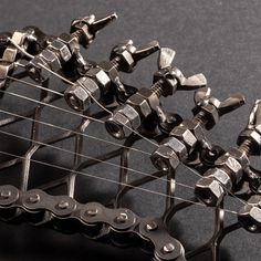 an electric guitar with many different tools attached to it's body and strings, on a black surface