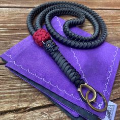 a pair of black and red leashes sitting on top of purple napkins