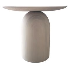 a white table with a circular base on it's top and an oval design at the bottom