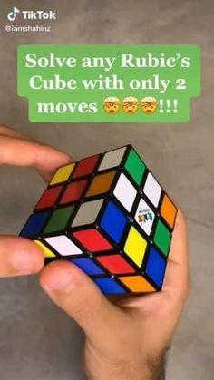 someone is holding a rubik cube with only 2 moves