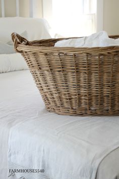 a wicker basket sitting on top of a bed