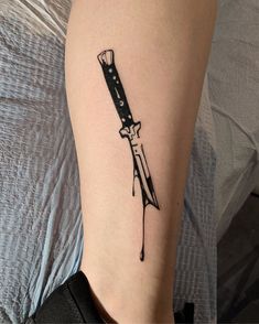 a knife tattoo on the leg of a woman