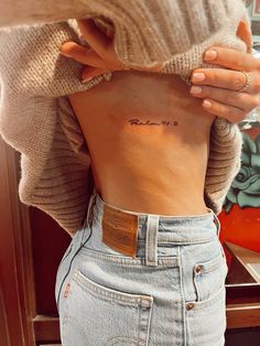 a woman with a small tattoo on her stomach and the word love is written in cursive writing