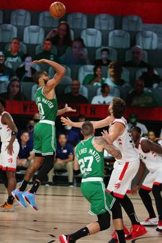 a group of men playing basketball against each other