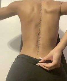 the back of a woman's body with writing on her lower back and upper part