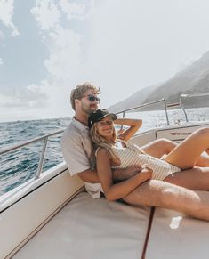 a man and woman sitting on the back of a boat