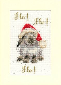 a cross stitch christmas card with an image of a bunny wearing a santa claus hat