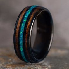 a wooden ring with blue and green inlays