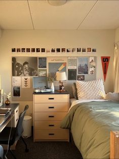 a bedroom with a bed, desk and pictures on the wall