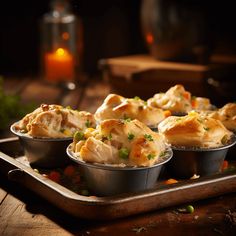 several small tins filled with food sitting on top of a wooden table next to a lit candle