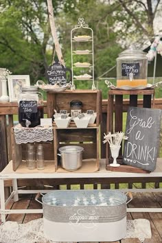 an outdoor buffet with chalkboard signs and drinks on the outside table for guests to enjoy