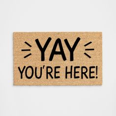 a door mat with the words yay you're here written in black on it