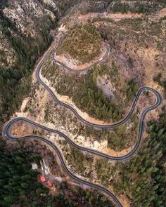 an aerial view of a winding road in the mountains