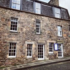 an old stone building with several windows on the side