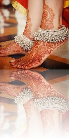 the feet and ankles of a woman with henna tattoos