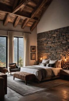 a large bedroom with stone walls and flooring, along with a bed that has a footstool on it