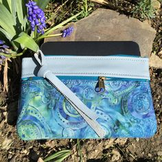 "Wallet, Clutch,or Phone case in Sky Blue Italian Leather paired with a pretty Boho Paisley Batik.This bag can carry your essentials and be your only bag-or use it in your big purse as I do for a wallet. Front zip works for change and top zip opens main section which fits dollar bills. There's also a small inside pocket that holds credit cards. Nice to carry jewelry when traveling. Or for your 7\" Knitting Needles and Crochet Hooks. 7 1/2\" wide 4 3/4\"deep PLEASE NOTE BATIK VARIES SLIGHTLY Matc Blue Rectangular Pouch For Daily Use, Rectangular Blue Pouch For Daily Use, Blue Rectangular Wallet With Mobile Phone Bag, Blue Pouch Bag With Card Slots, Blue Rectangular Wallet With Cell Phone Pocket, Blue Travel Clutch With Mobile Phone Bag, Blue Rectangular Clutch With Card Slots, Everyday Blue Rectangular Clutch, Blue Bohemian Rectangular Pouch