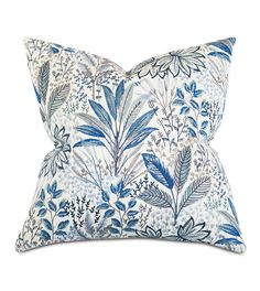 a blue and white floral pillow on a white background