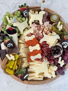 a wooden platter filled with different types of cheeses and meats on sticks