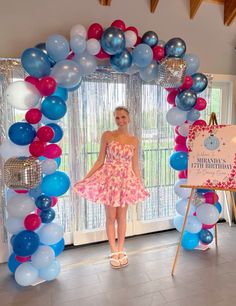 a woman standing in front of a balloon arch