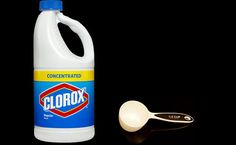 a bottle of clorox liquid next to a measuring spoon and scoop on a black background