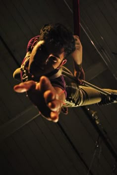 a man hanging upside down in the air with his hands out and pointing at something