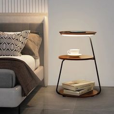 a bed with two books and a lamp next to it on a table in front of the bed