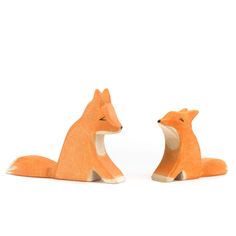 two wooden foxes sitting next to each other