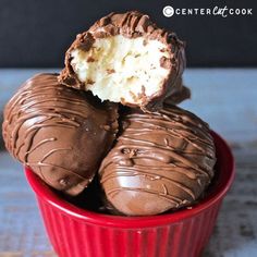 three chocolate covered desserts in a red bowl