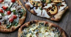 four pizzas with different toppings sitting on top of a wooden table next to each other