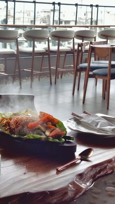 a table with some food on top of it next to chairs and tables in the background