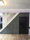 an empty living room with hard wood flooring and white stairs leading up to the second floor