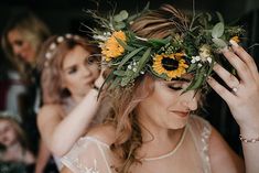 the bride is getting ready to walk down the aisle with her sunflower wreath on her head