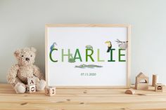 a teddy bear sitting next to a wooden frame with the word charlie written in green