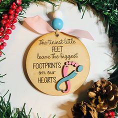 a wooden ornament hanging on a christmas tree with pine cones and red berries