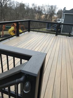 a wooden deck with black rails and railings