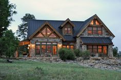 a large stone and wood house in the evening